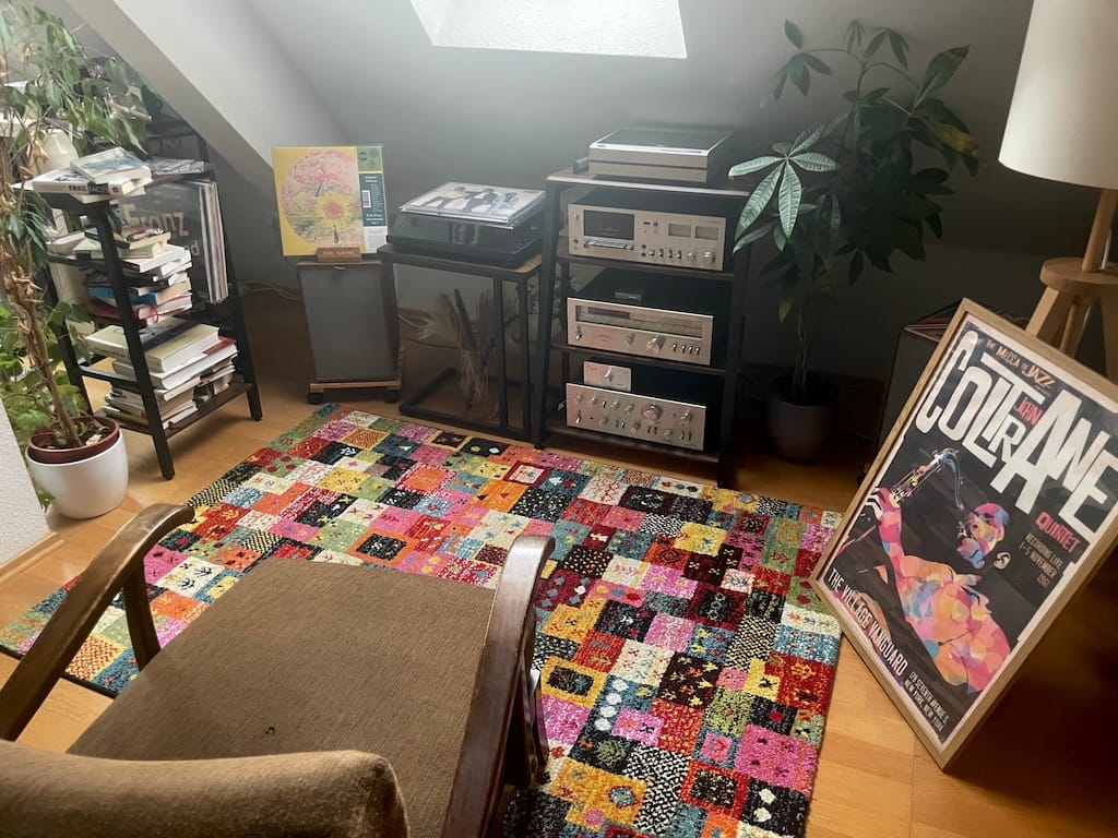 Meine Musikecke mit buntem Teppich, John Coltrane, Pflanzen, Büchern und dem Vintage Hifi Rack.