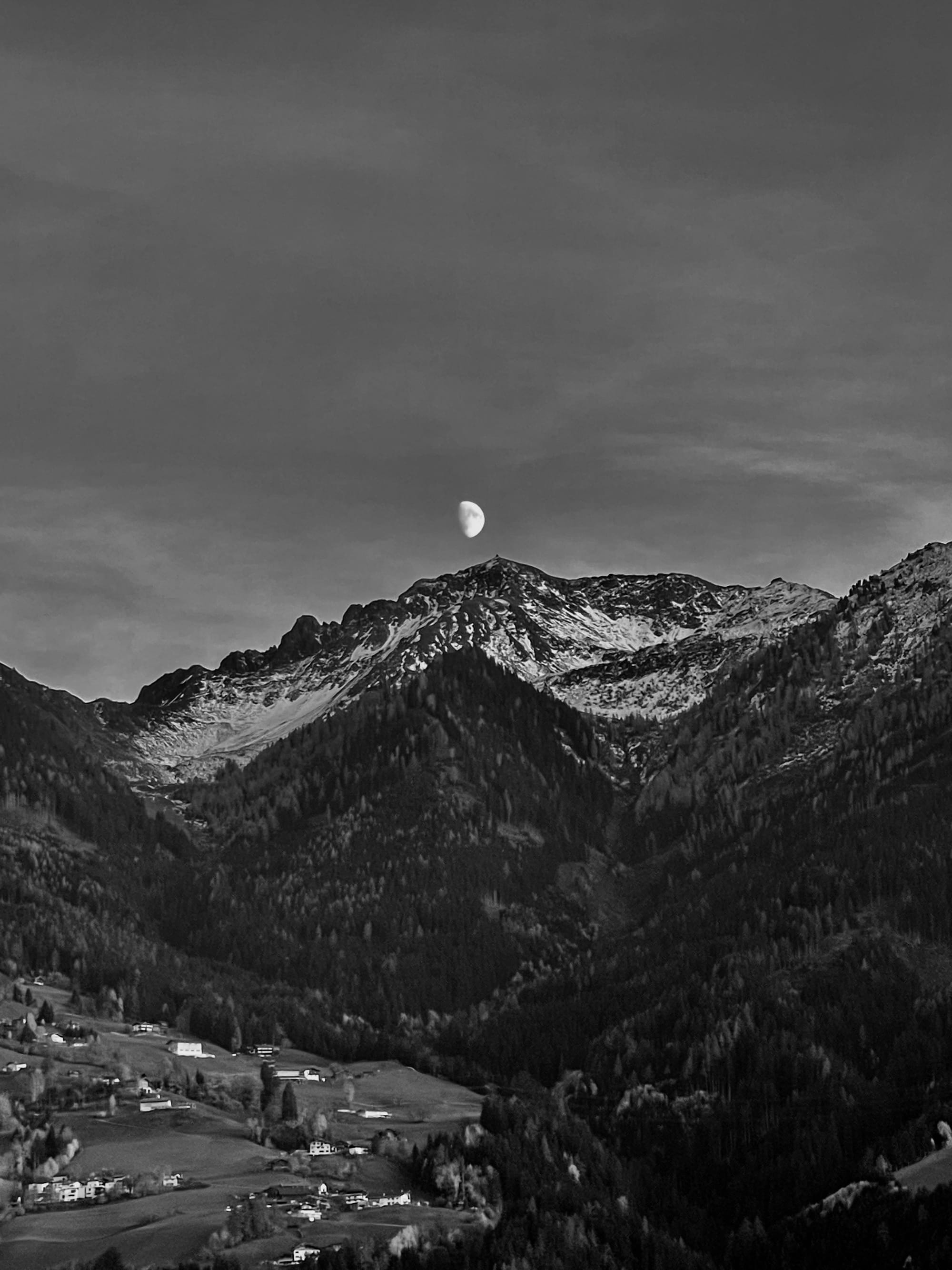 Der noch nicht volle Mond über den Bergen in Tirol im Oktober 2025