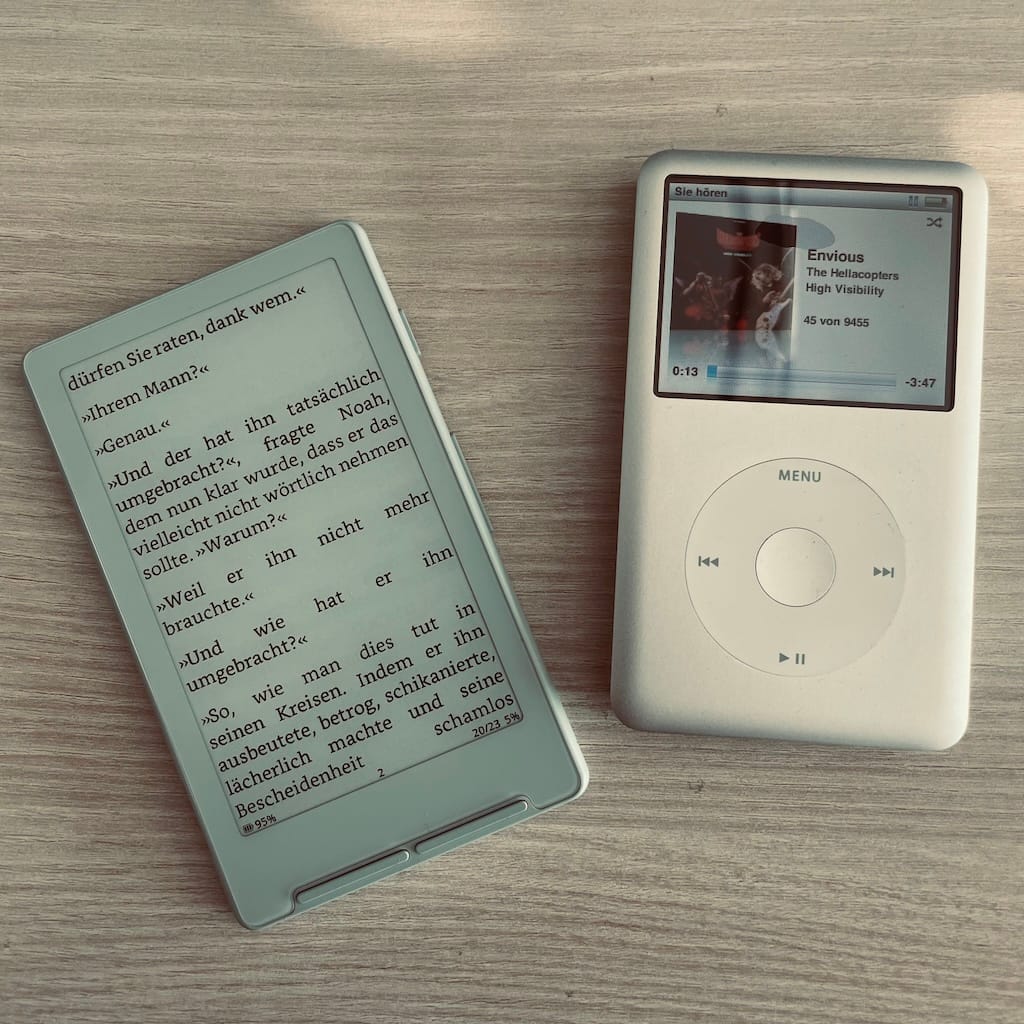 Mein Xteink X4 (mit dem Buch Wut und Liebe) und mein iPod Classic (mit dem Song Envious der mighty Hellacopters) auf einem Tisch